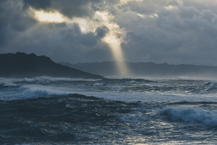 Mar tormentoso del Atlántico con un rayo de luz atravesando las nubes